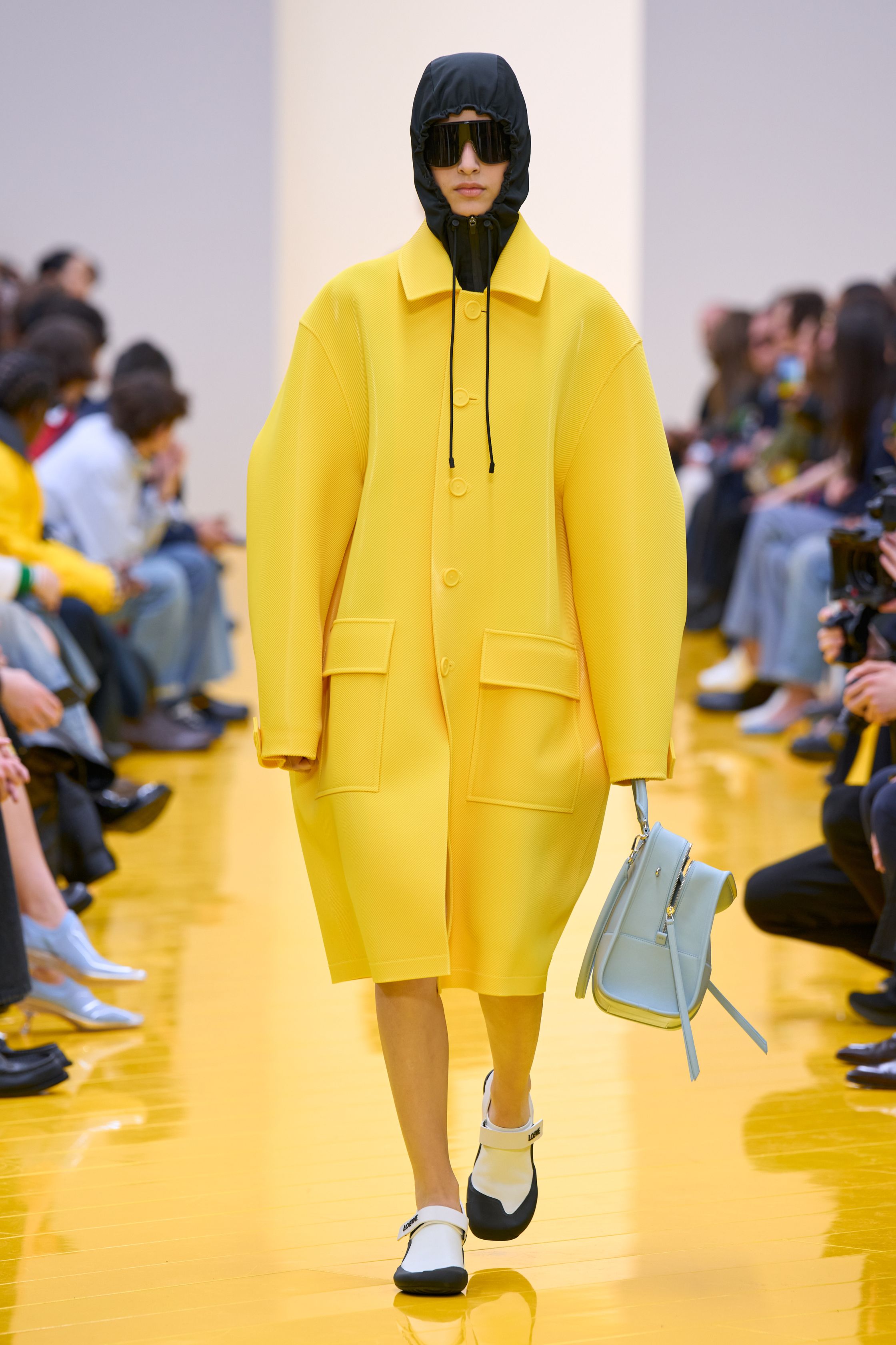 Jonathan Anderson 为 Loewe 带来一场充满艺术实验的秀：黄色地面与鲜明色彩形成强烈视觉舞台，极简廓形针织、雕塑化皮革外套、夸张毛绒结构和实验比例裙装共同构建一种“可穿戴雕塑”。从鲜黄、亮蓝到浓郁棕色毛绒，材质对比成为本季核心语言，既有幽默感也带有博物馆式艺术气质-顽石频道趋势研究